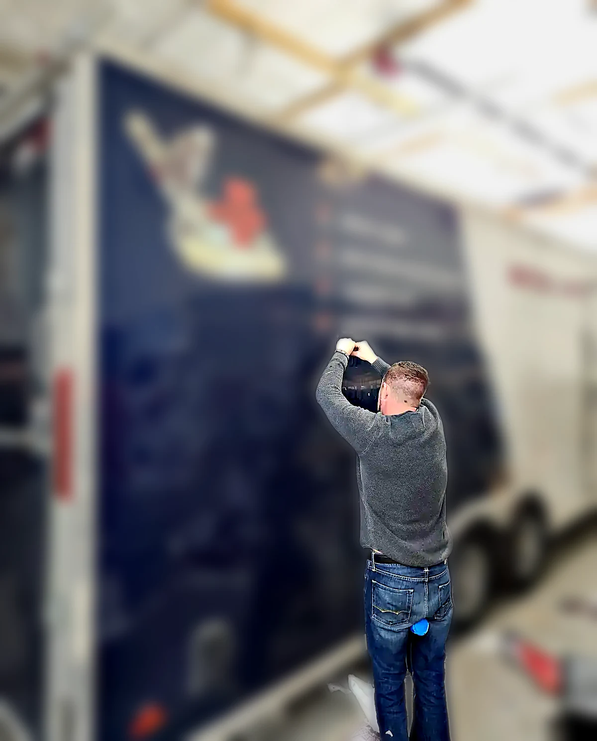 Technician removing vehicle wrap graphics from a commercial fleet van at Chicago Fleet Wraps facility